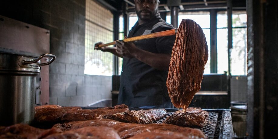 Rodney-Scott-BBQ Rodney Scott mops racks of ribs