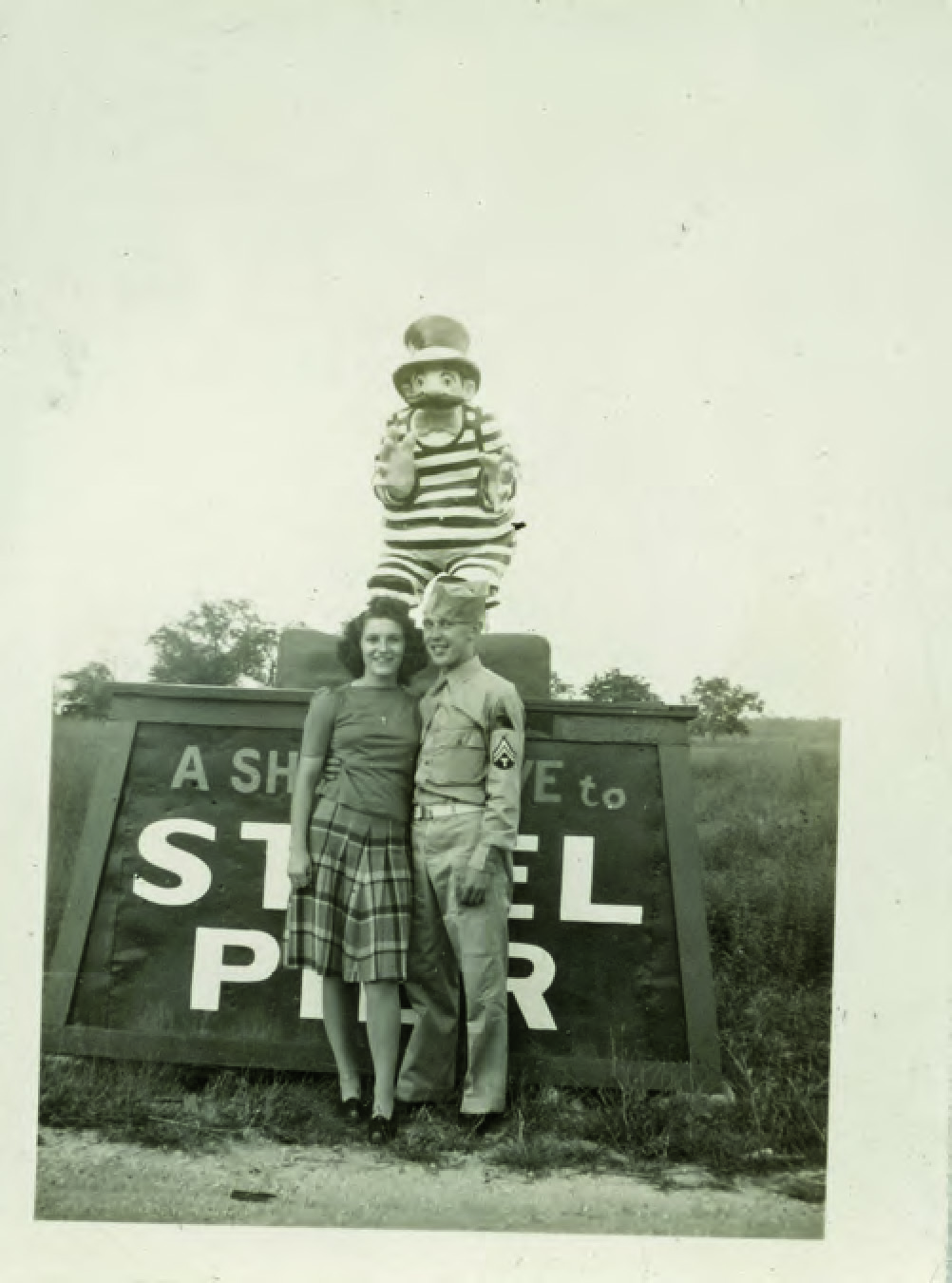 A couple standing in front of a promotional Atlantic City Steel Pier sign/statue